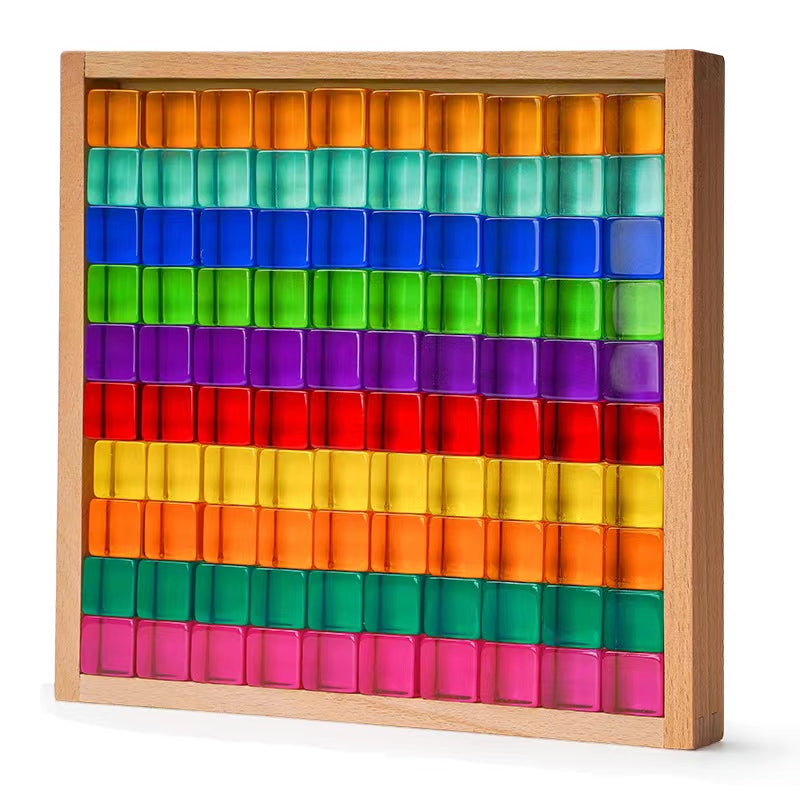 One hundred rainbow lucite cubes arranged by color in a wooden storage tray