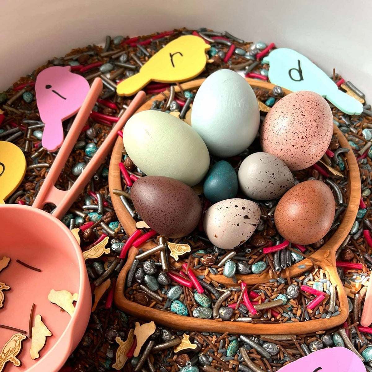 Wooden bird eggs in a sensory-play setup