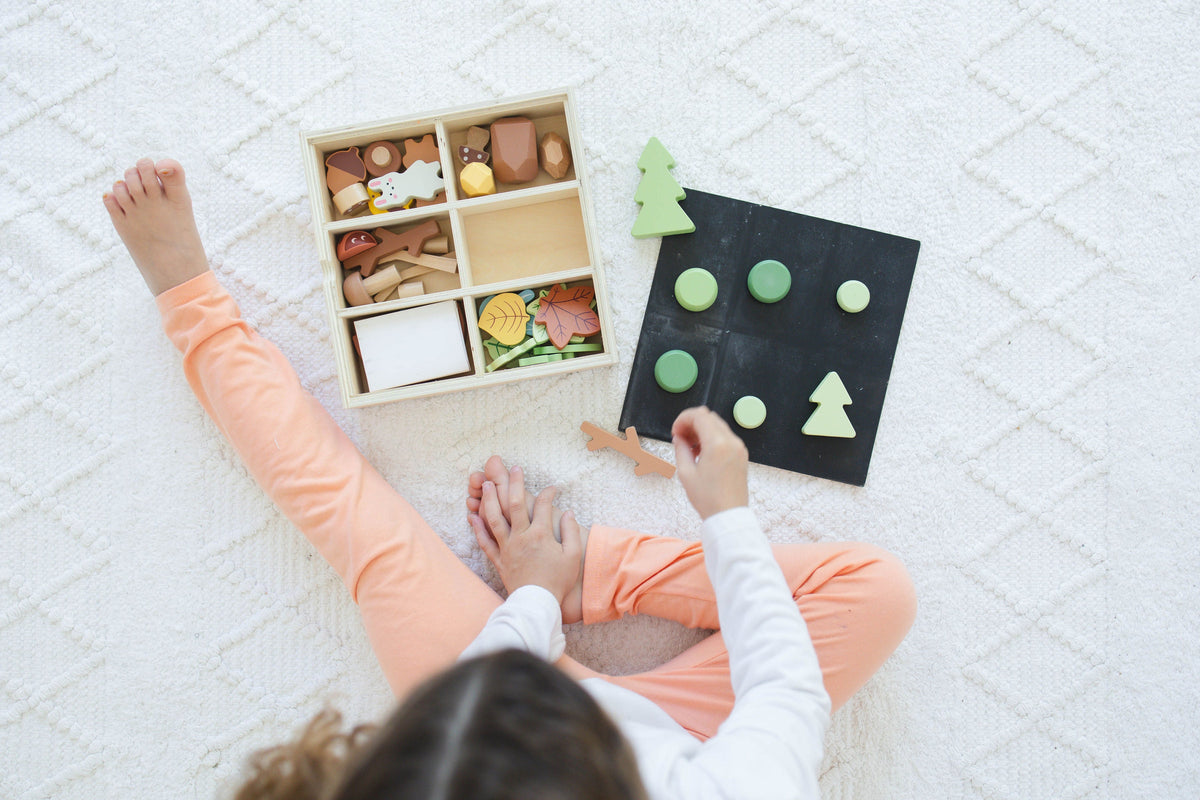 SpiritnSprout: Overhead view of a child using the forest set and chalkboard lid