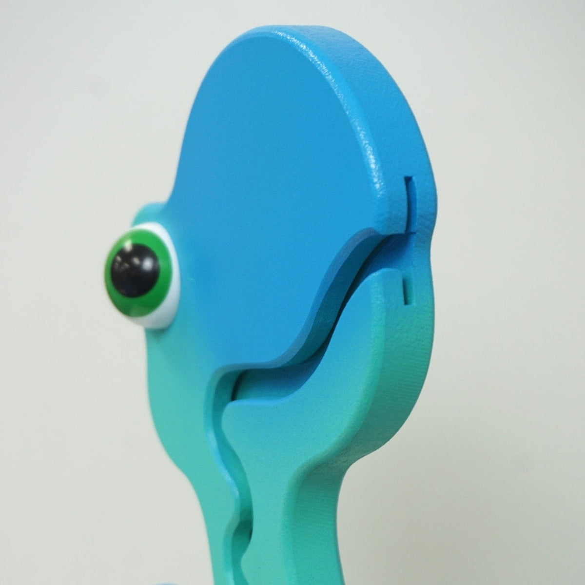Side close-up of the aqua dinosaur head and coin-entry slot