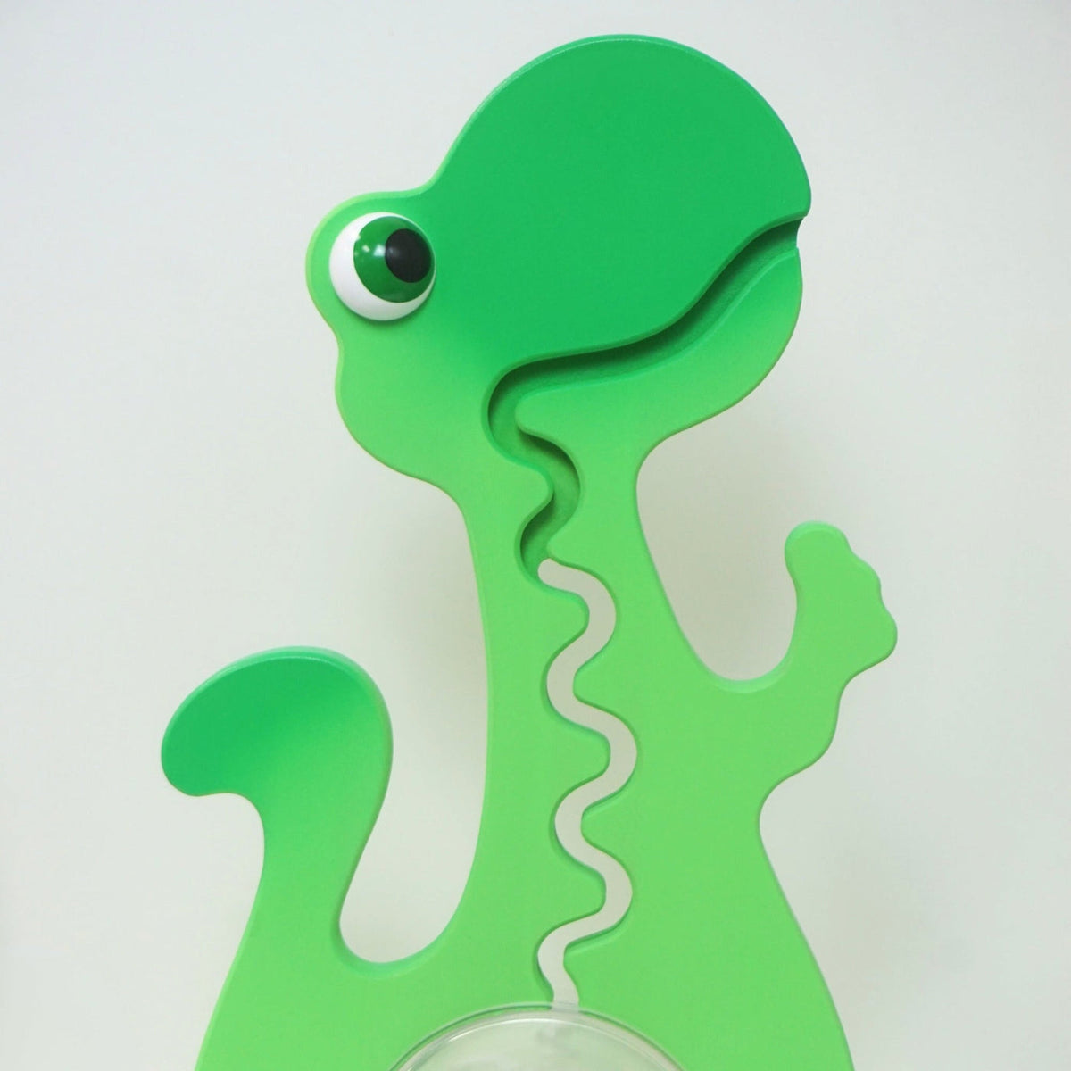 Close-up of the green dinosaur head and front coin track