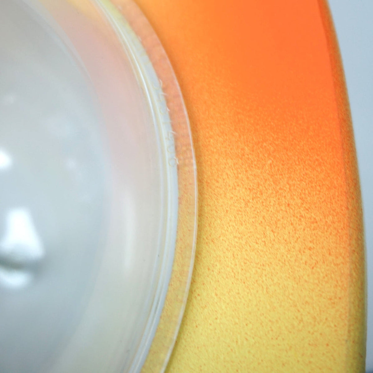 Close-up of the giraffe bank orange and yellow finish beside the clear belly