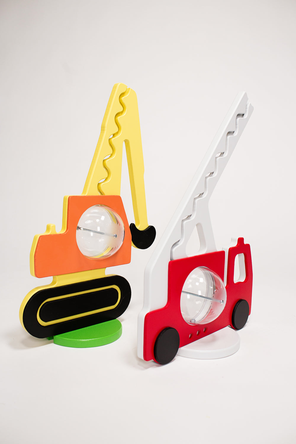 Excavator coin bank displayed beside a red fire-truck coin bank