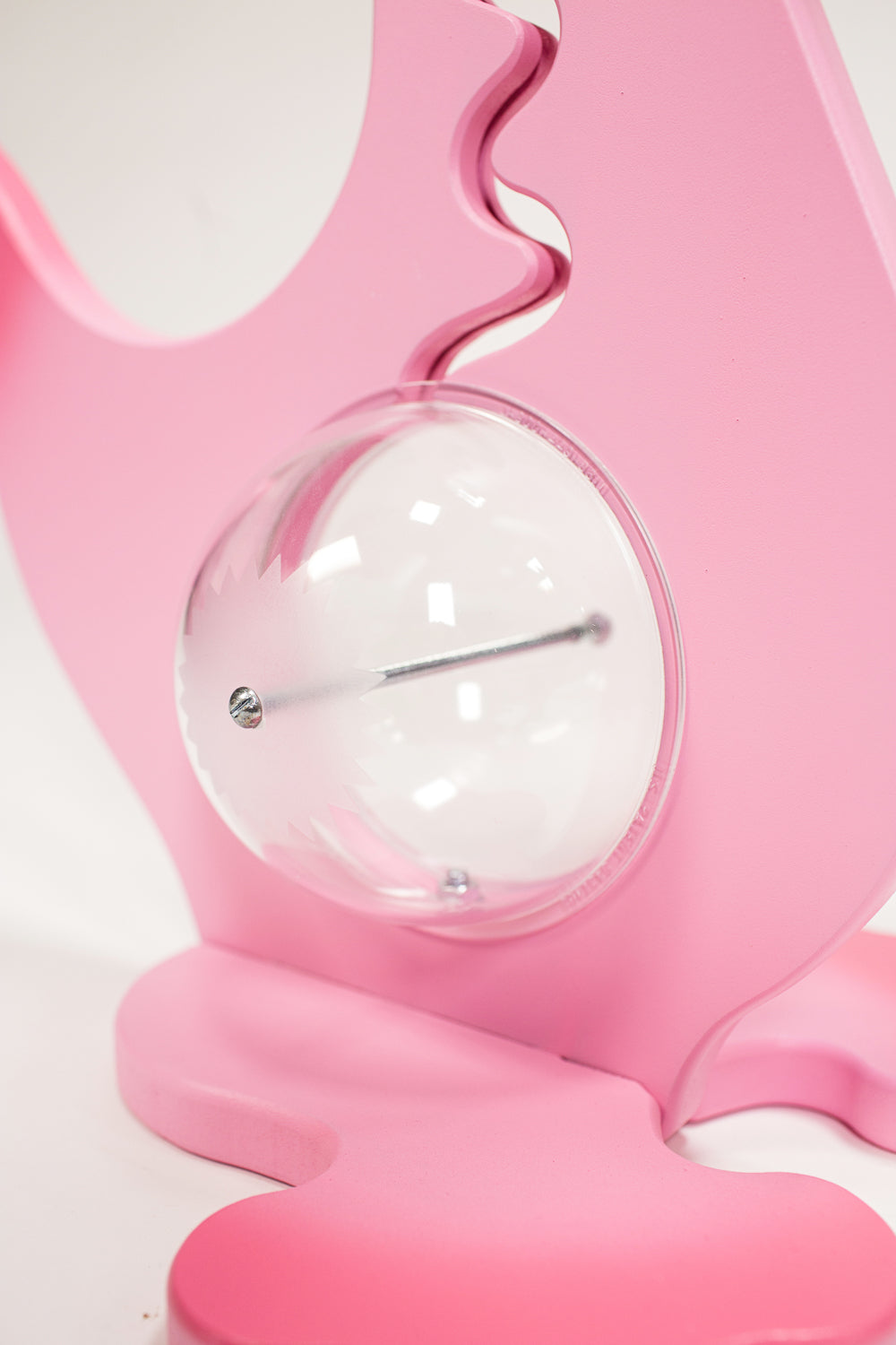 Close-up of the pink dinosaur bank clear belly, metal bolt and base