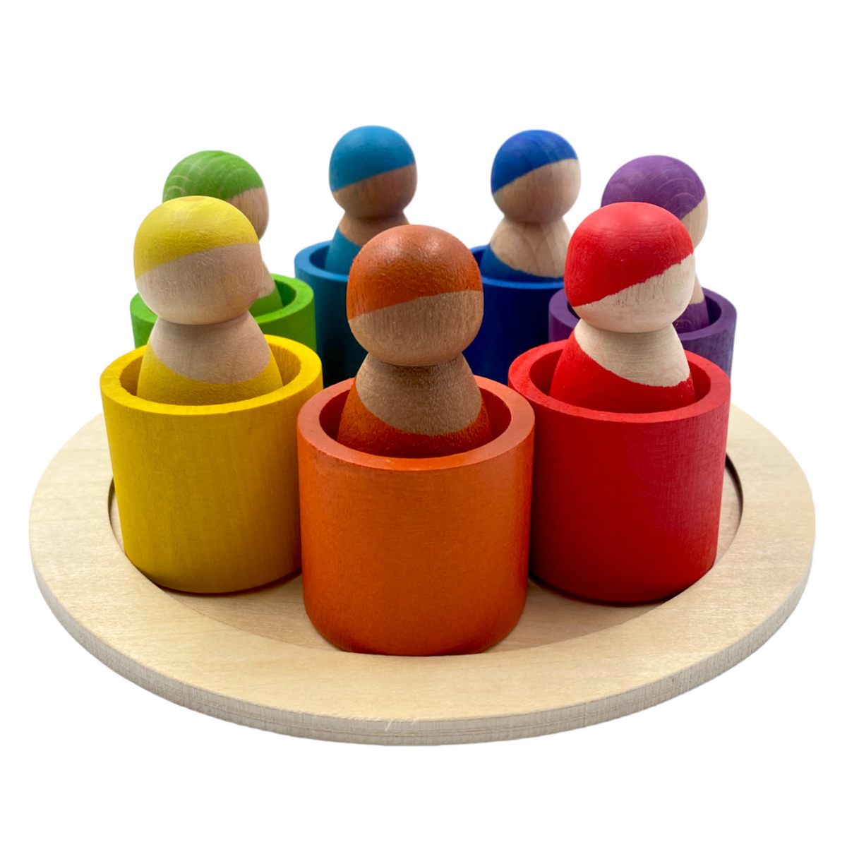 Seven wooden peg dolls in rainbow bowls on a circular wooden tray