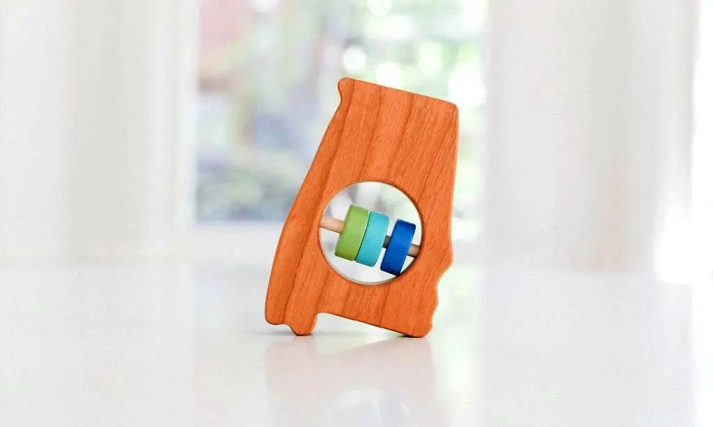 Bannor Toys Alabama State Wooden Baby Rattle, showing state-shaped cherry-wood body and colored rattle discs