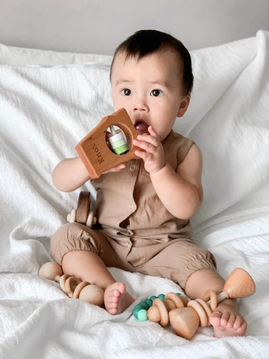 Lifestyle photo showing a wooden state rattle with a child