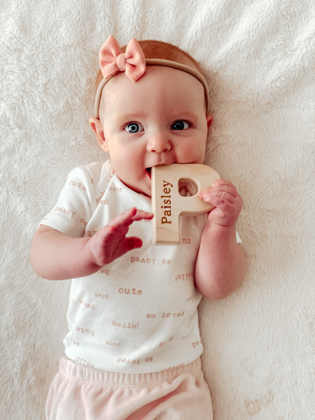 Lifestyle photo showing a wooden grasping toy with a child