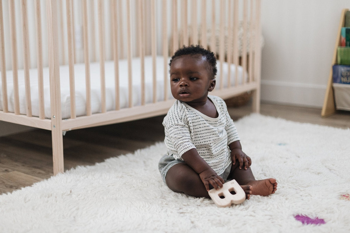 Lifestyle photo showing a wooden grasping toy with a child