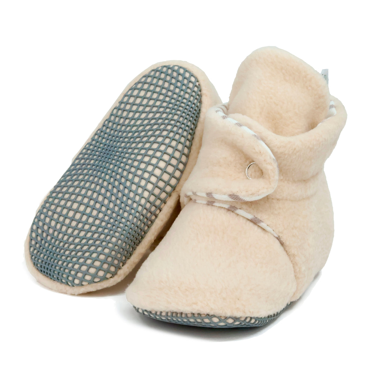 Cream fleece baby booties with pale striped lining and snap straps, with one sole facing the camera on a white background.