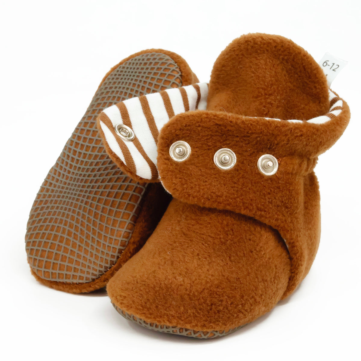Warm brown fleece baby booties with striped lining and snap straps, showing one sole and an open snap strap on white.