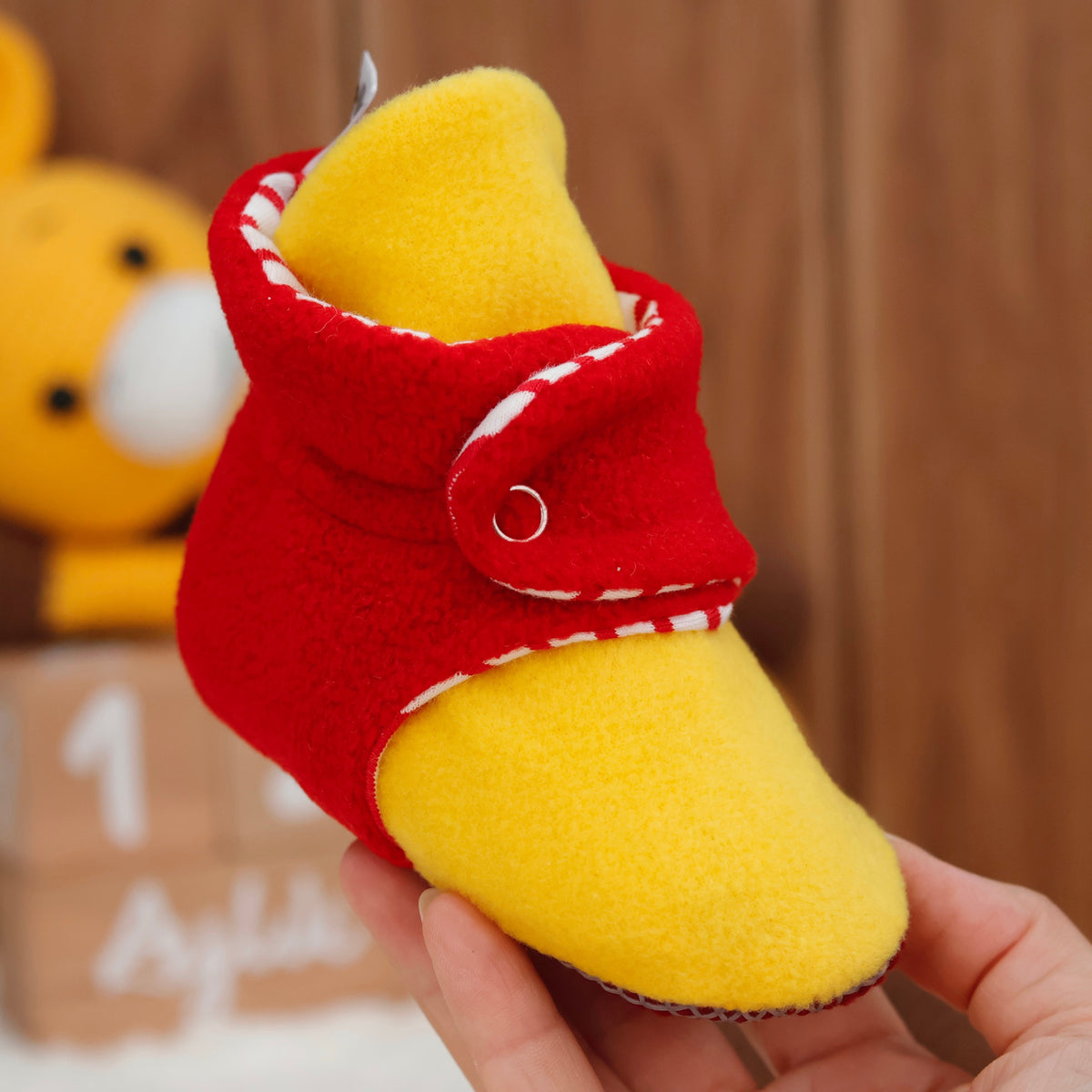 Single bootie held in a hand, side view.