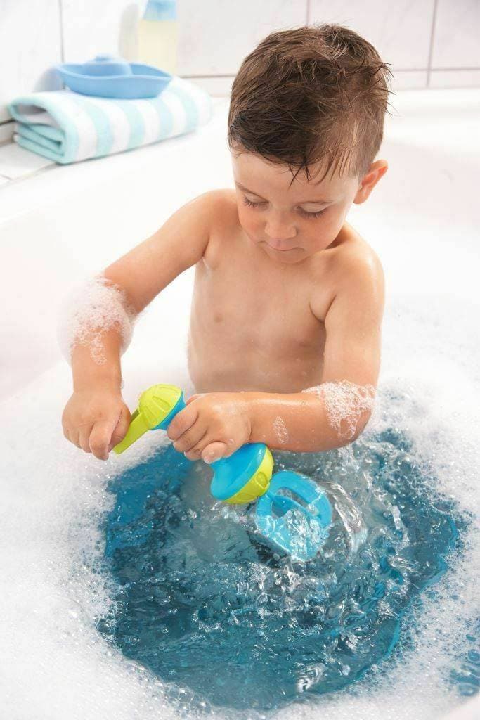 A child turning the lime green crank on the blue HABA Bubble Bath Whisk in the bath