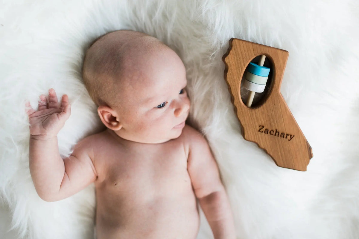 Lifestyle photo showing a wooden state rattle with a child