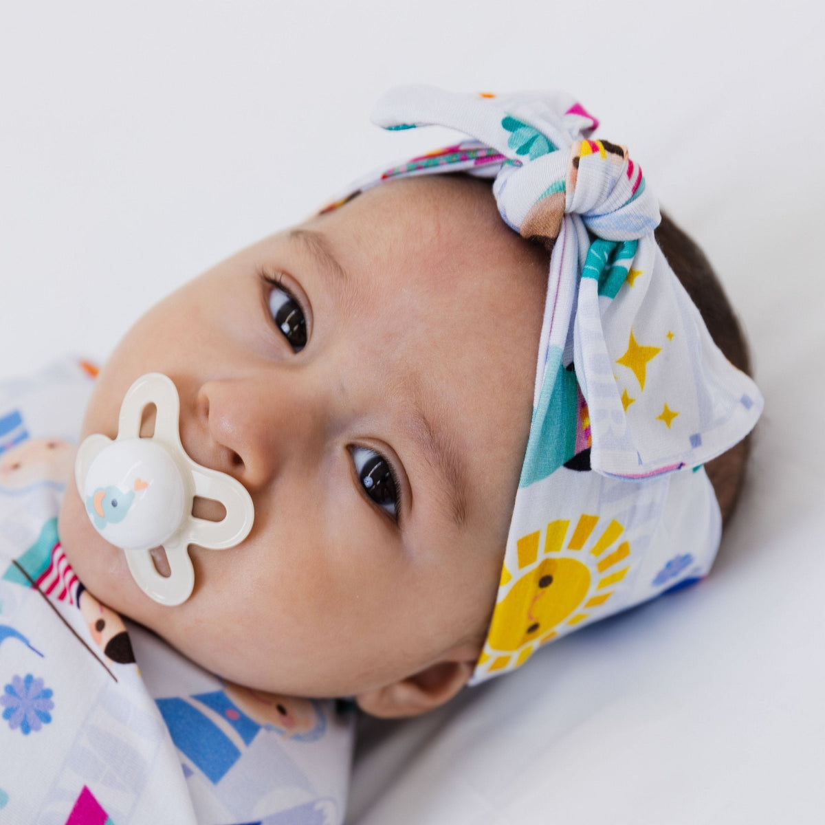 Close-up of a baby wearing Bam & Stitch Children of the World Bow Headband.