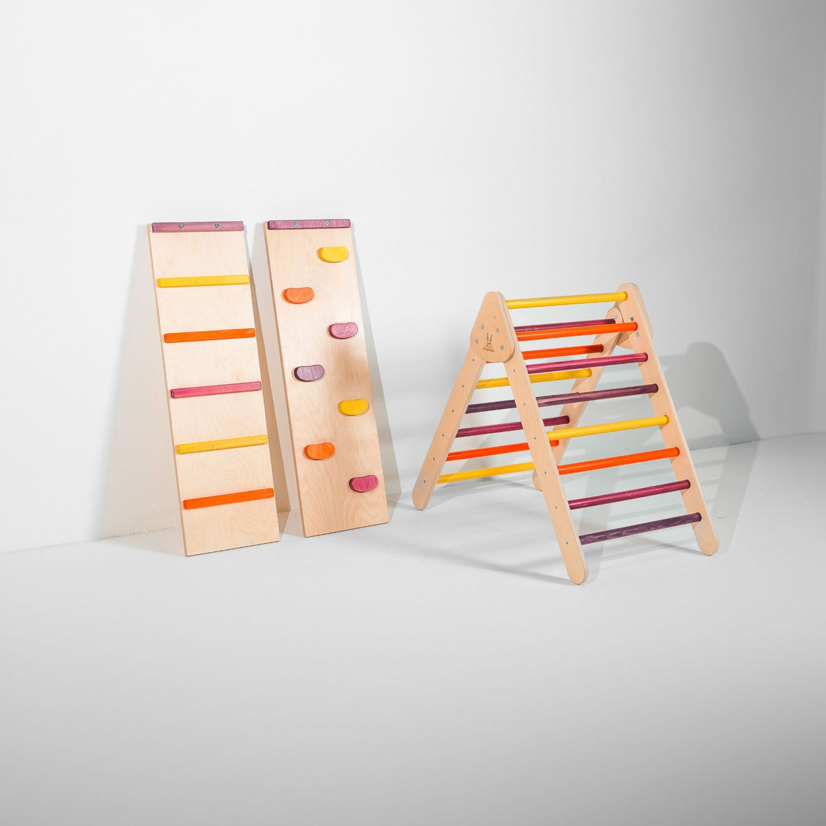 Classic Climber triangle with pink, purple, orange and yellow rungs beside two upright ramps.