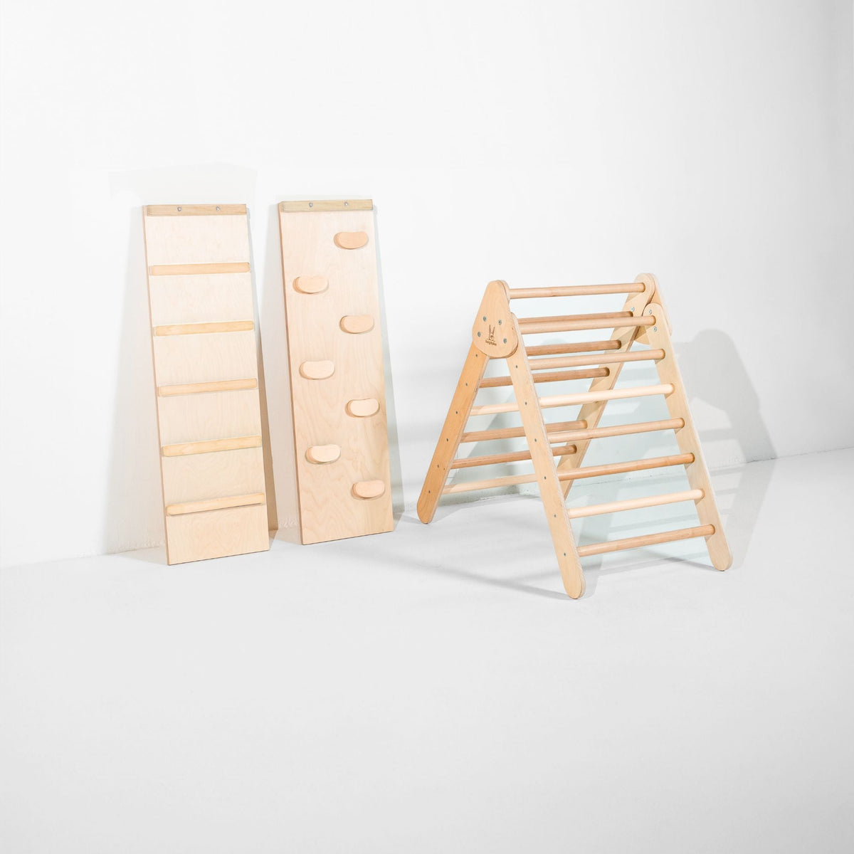Light natural-tone Classic Climber triangle beside upright ladder and climbing-hold ramps.