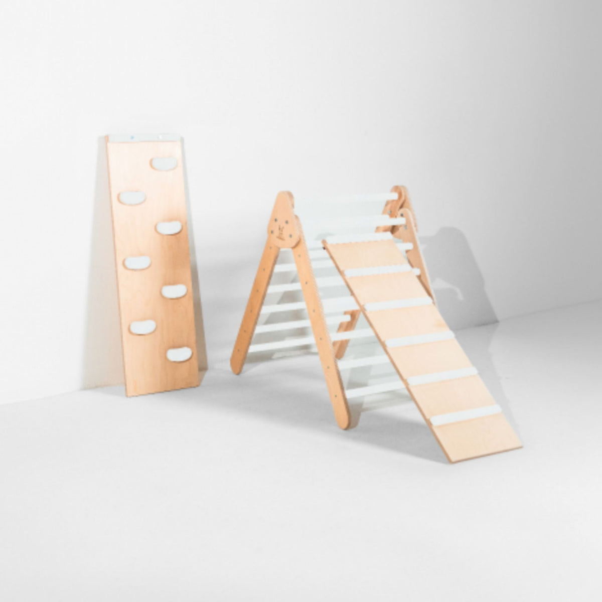 White-rung triangle with attached ladder ramp and a white-hold climbing ramp beside it.
