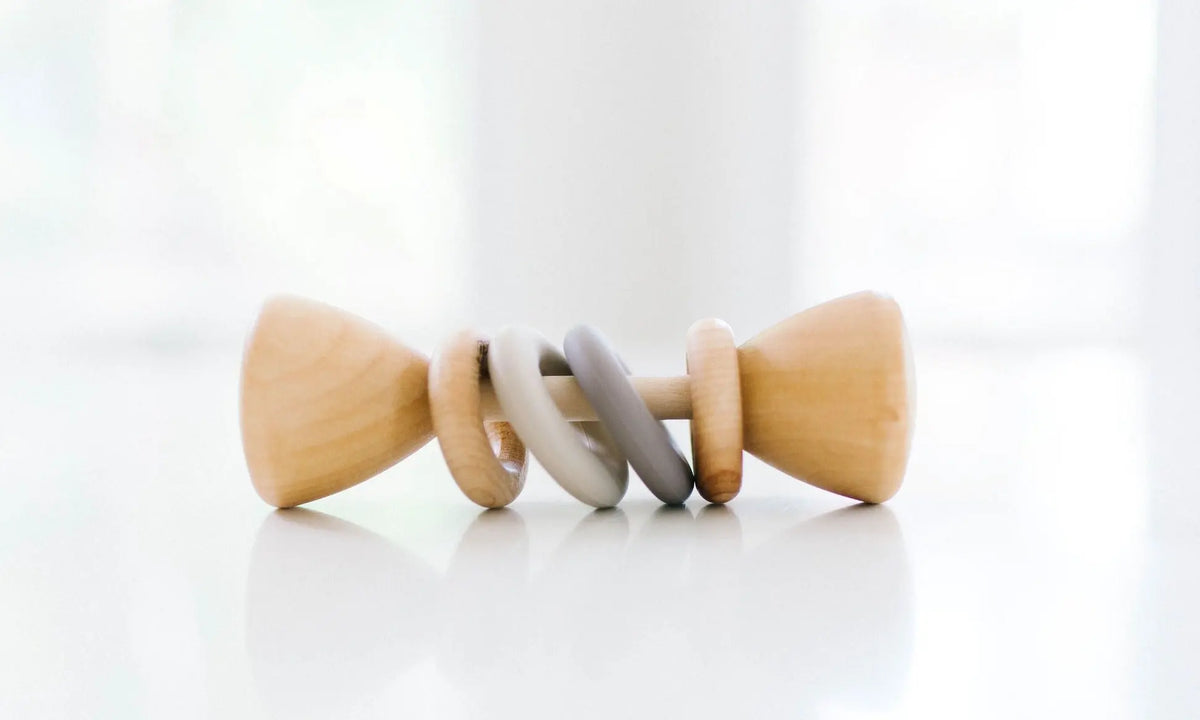 Bannor Toys Color Block Classic Baby Rattle, showing wooden body and colored silicone rings