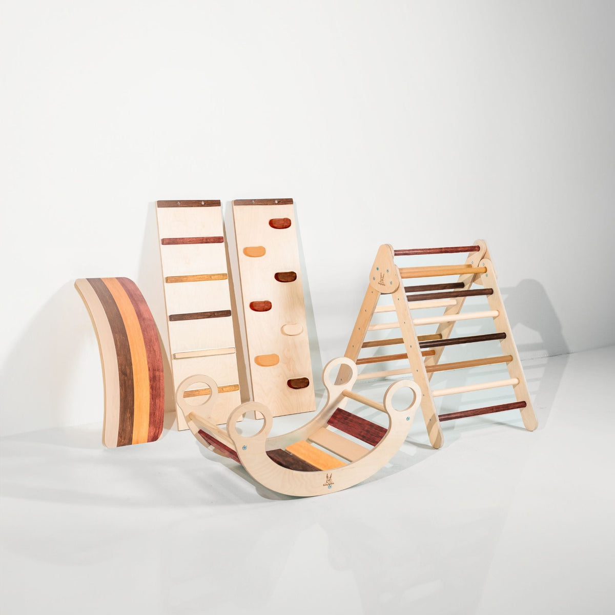 Mixed brown and cream climbing triangle, two ramps, striped wobble board and rocker displayed together.