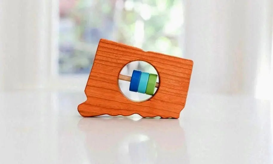 Bannor Toys Connecticut State Wooden Baby Rattle, showing state-shaped cherry-wood body and colored rattle discs