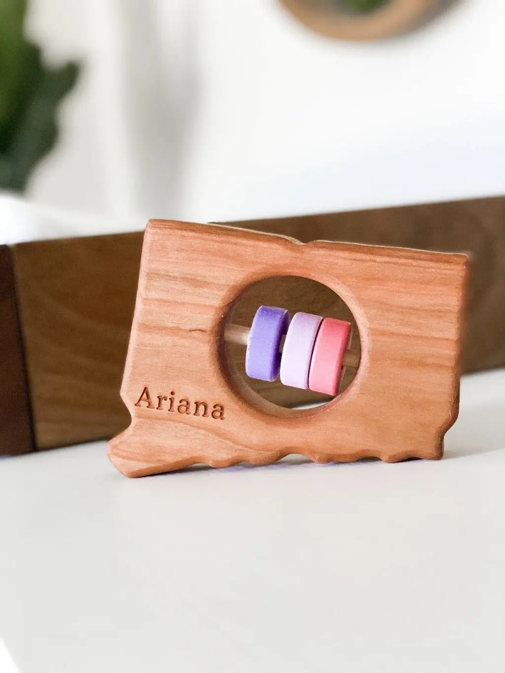 Bannor Toys Connecticut State Wooden Baby Rattle with example laser engraving and colored rattle discs