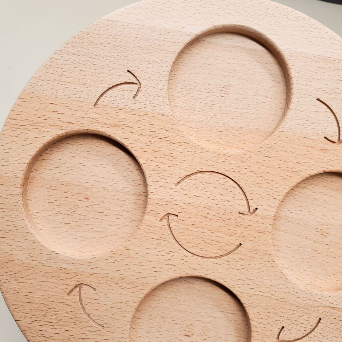 Close-up of engraved arrows and recessed spaces on the wooden board