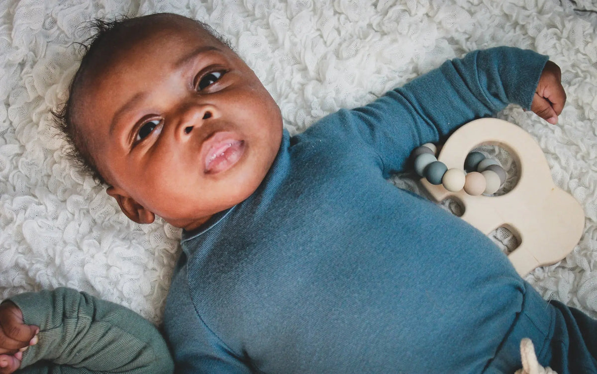 Lifestyle photo showing a wooden grasping toy with a child