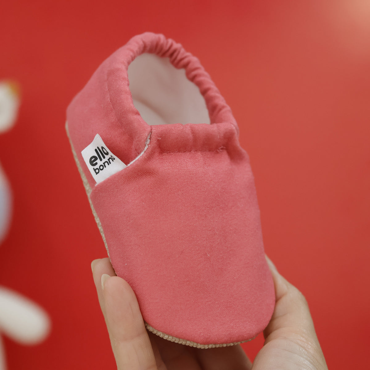 Single moccasin held in a hand, front view.
