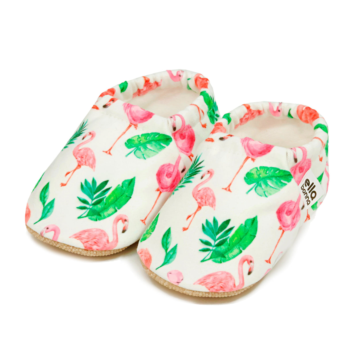 Pair of cream slip-on baby moccasins with pink flamingos and green leaves on a white background.