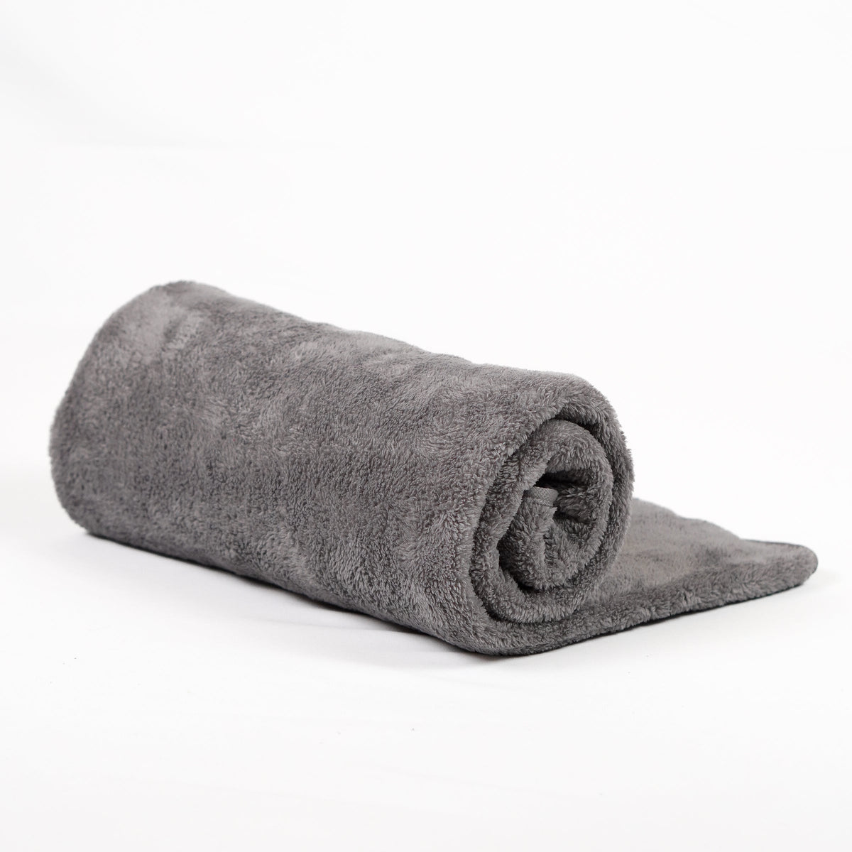 Gray fleece blanket rolled on white.