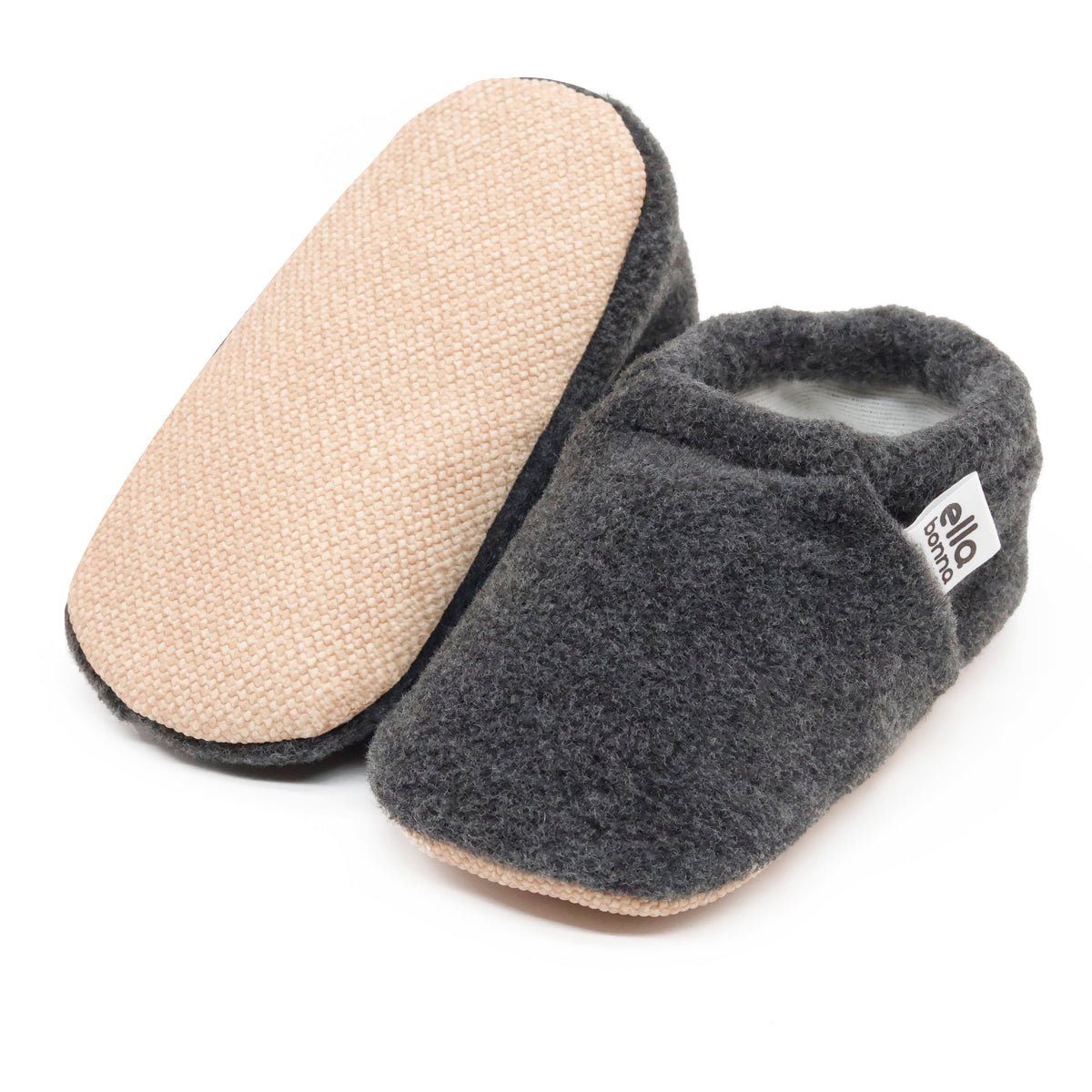 Charcoal fleece slip-on baby moccasins with tan soles, with one sole facing the camera on a white background.