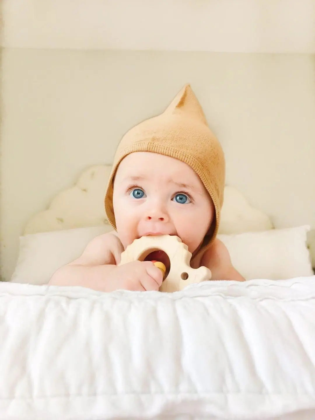Lifestyle photo showing a wooden grasping toy with a child