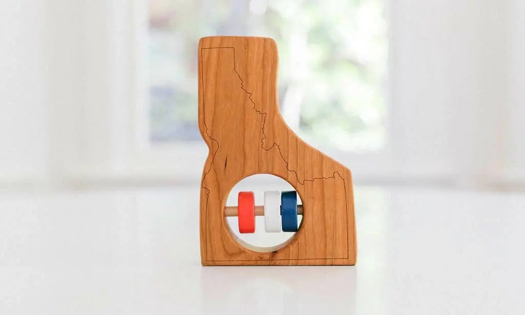 Bannor Toys Idaho State Wooden Baby Rattle, showing state-shaped cherry-wood body and colored rattle discs