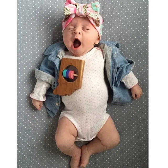 Lifestyle photo showing a wooden state rattle with a child