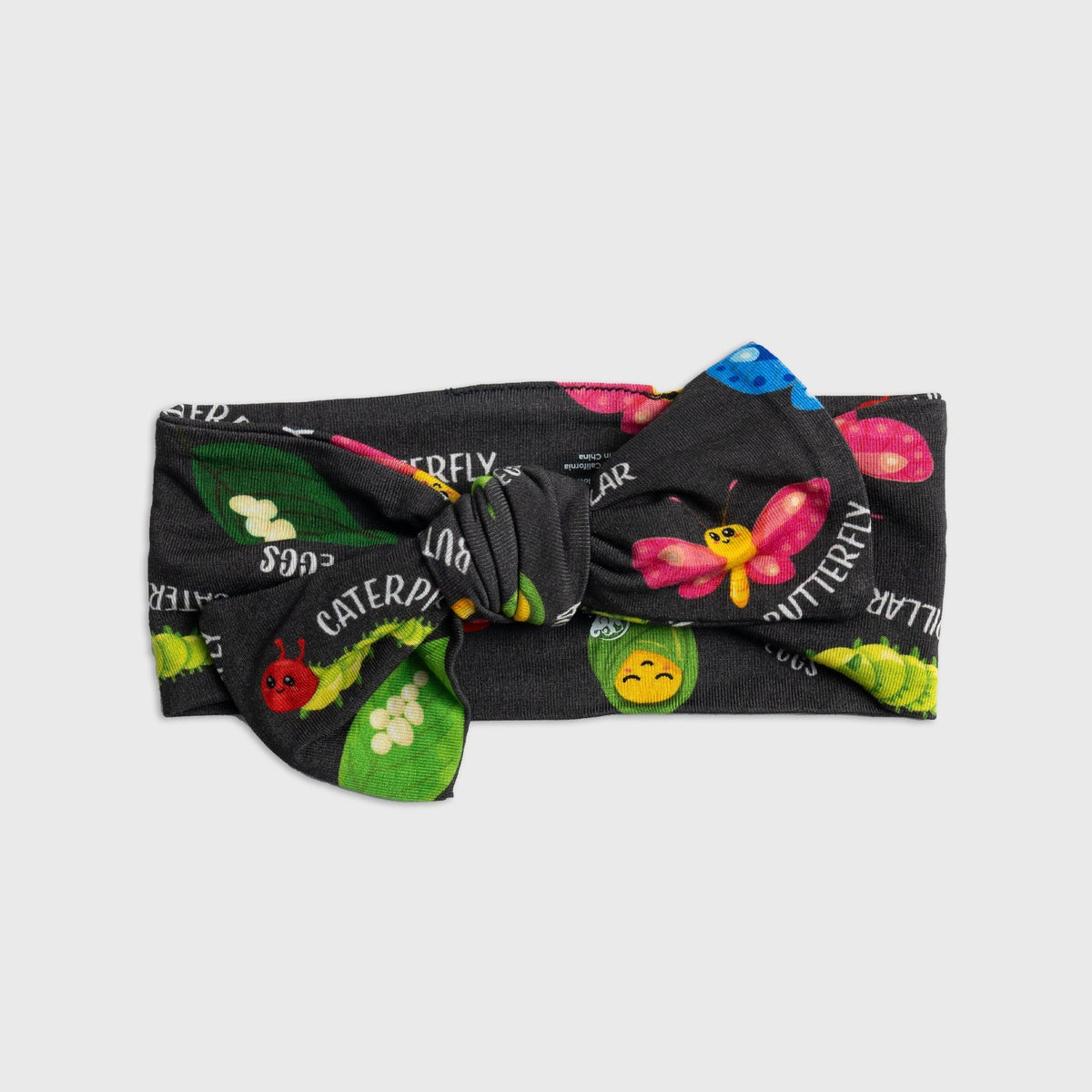Flat lay of Bam & Stitch It's Morphing Time! Bow Headband, showing the bow and fabric band.