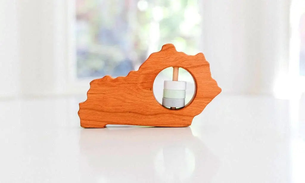 Bannor Toys Kentucky State Wooden Baby Rattle, showing state-shaped cherry-wood body and colored rattle discs