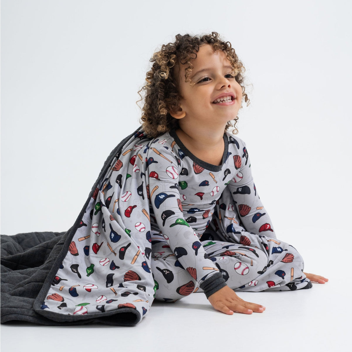 Child seated with Bam & Stitch Major League Buddies Blanket wrapped around them.