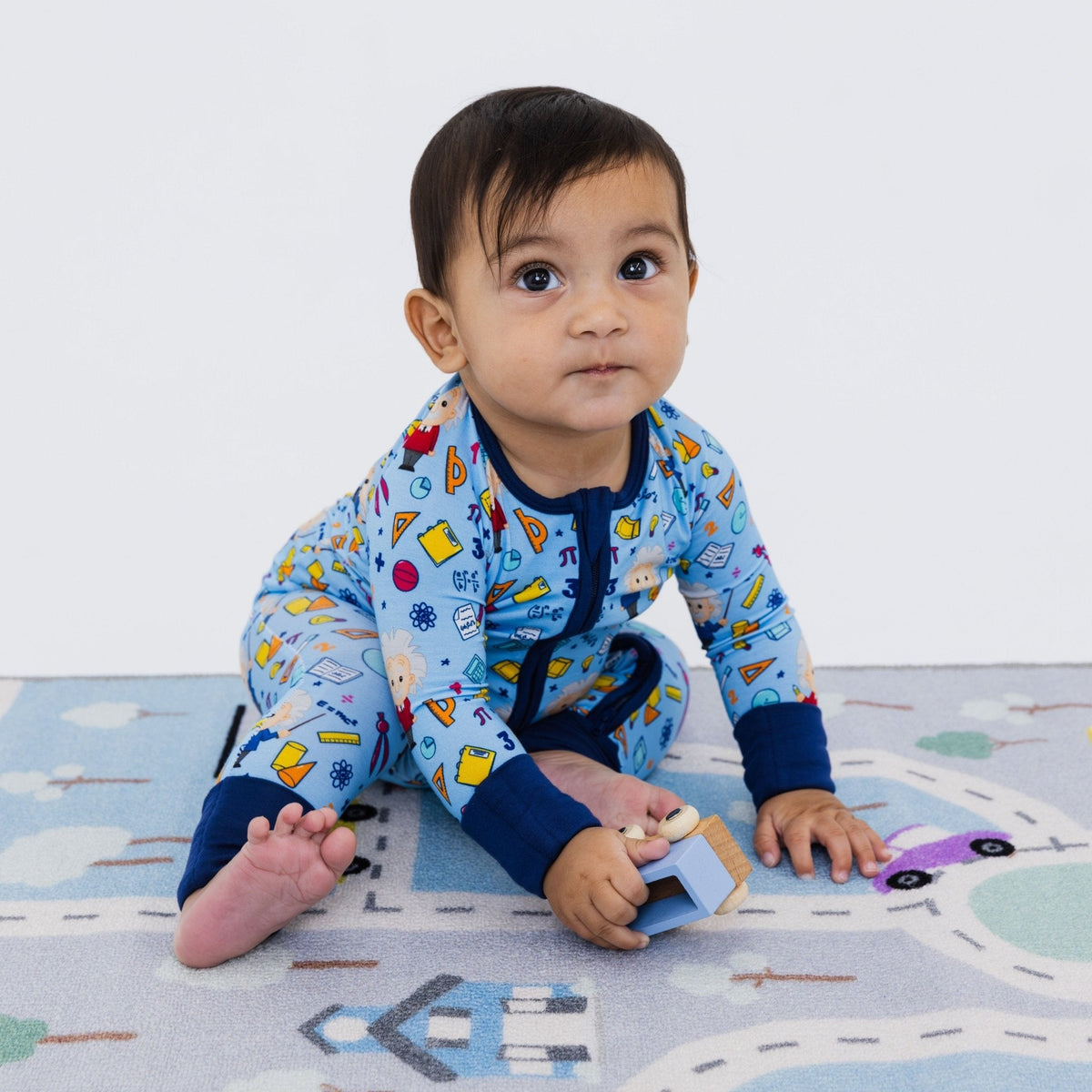 Baby playing while seated in Bam & Stitch Mathematical Marvel Convertible Romper.