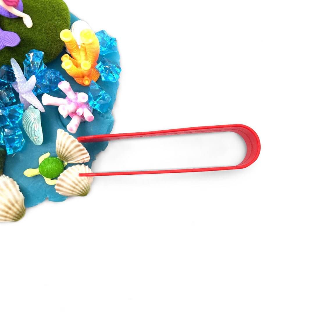 Overhead view of red tongs beside the Mermaid Seascape playdough scene