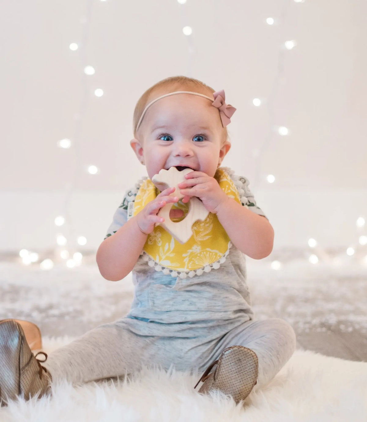 Lifestyle photo showing a wooden grasping toy with a child