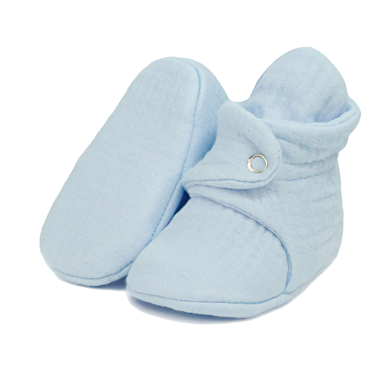 Light blue textured muslin baby booties with snap straps, with one sole facing the camera on a white background.