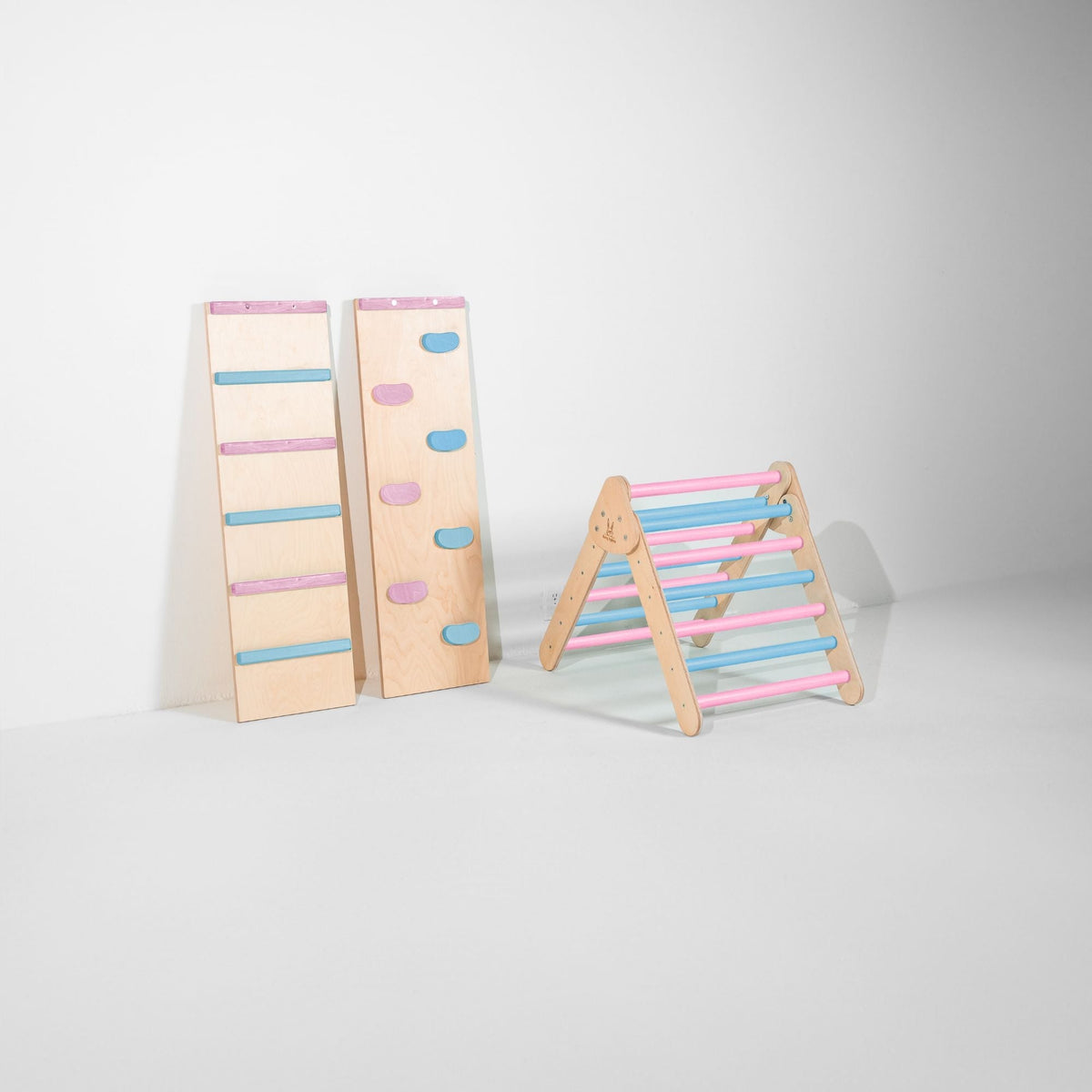 Small pastel blue and pink climbing triangle beside two upright ramps.