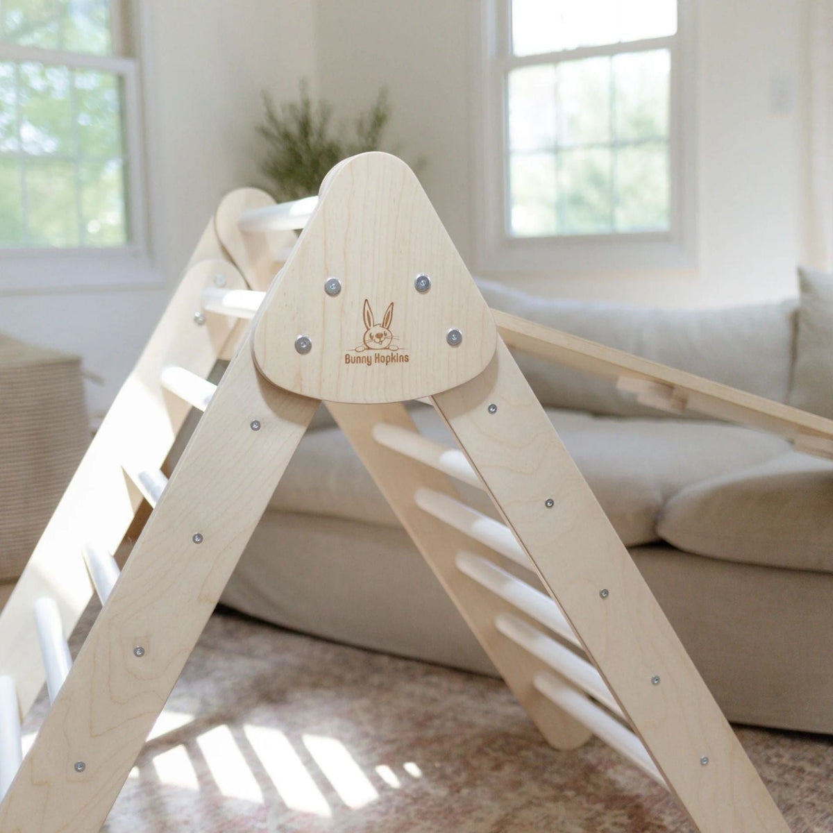 Close-up of the rounded top joint, logo and white rungs of a climbing triangle.