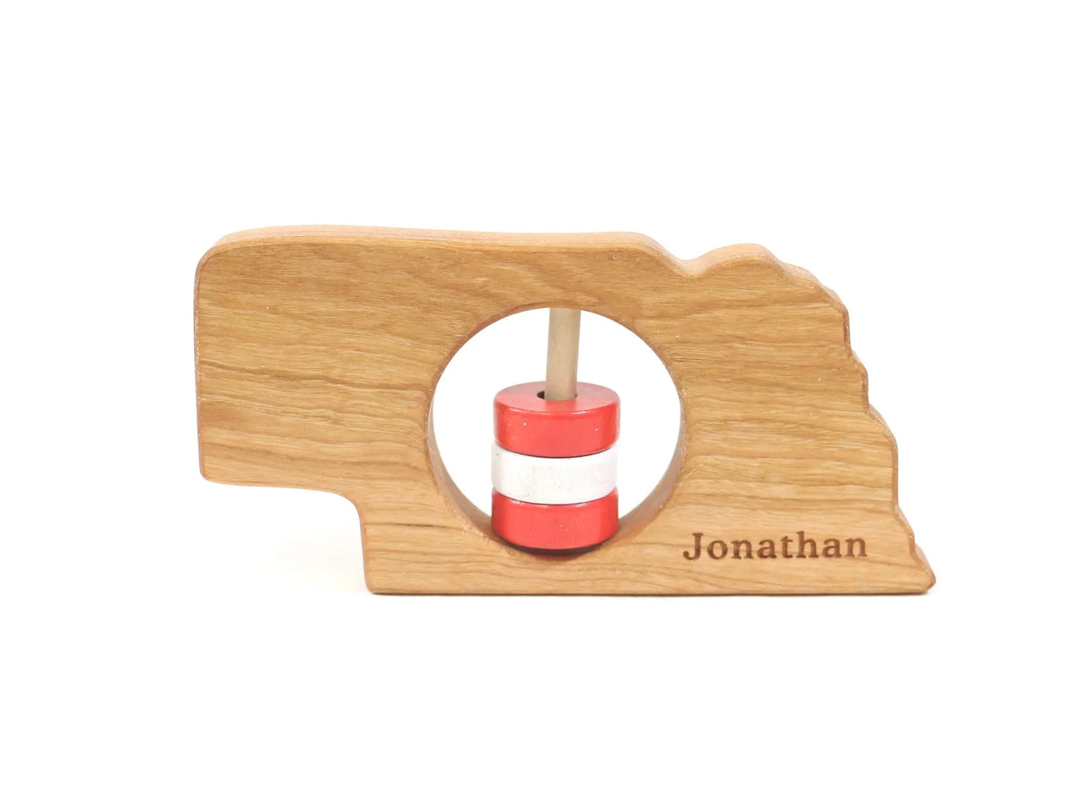 Bannor Toys Nebraska State Wooden Baby Rattle with example laser engraving and colored rattle discs