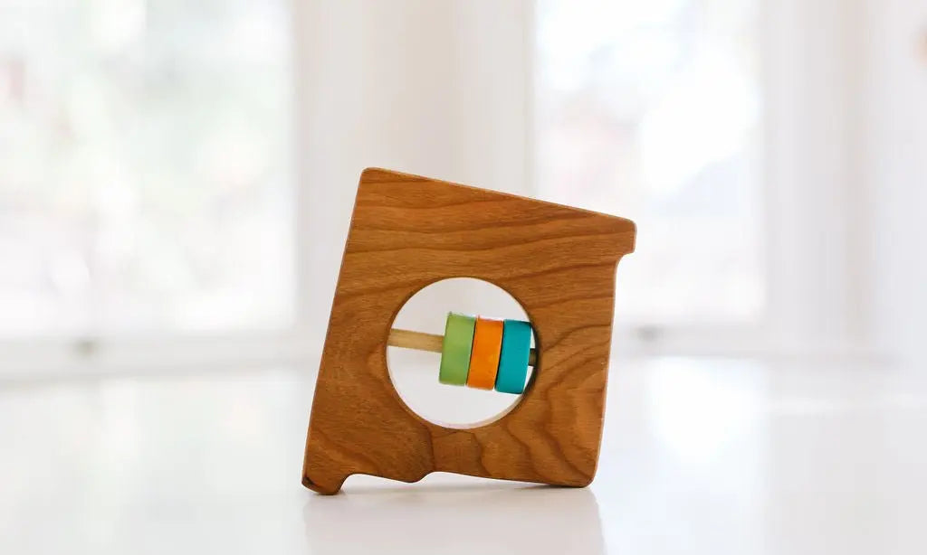 Bannor Toys New Mexico State Wooden Baby Rattle, showing state-shaped cherry-wood body and colored rattle discs