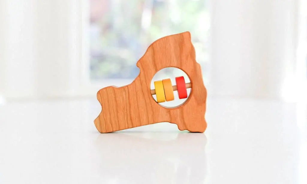 Bannor Toys New York State Wooden Baby Rattle, showing state-shaped cherry-wood body and colored rattle discs