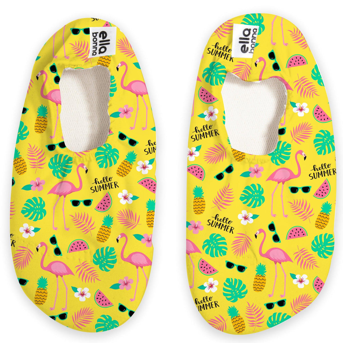 Top view of a pair of yellow slip-on water shoes with pink flamingos, pineapples and green leaves on a white background.