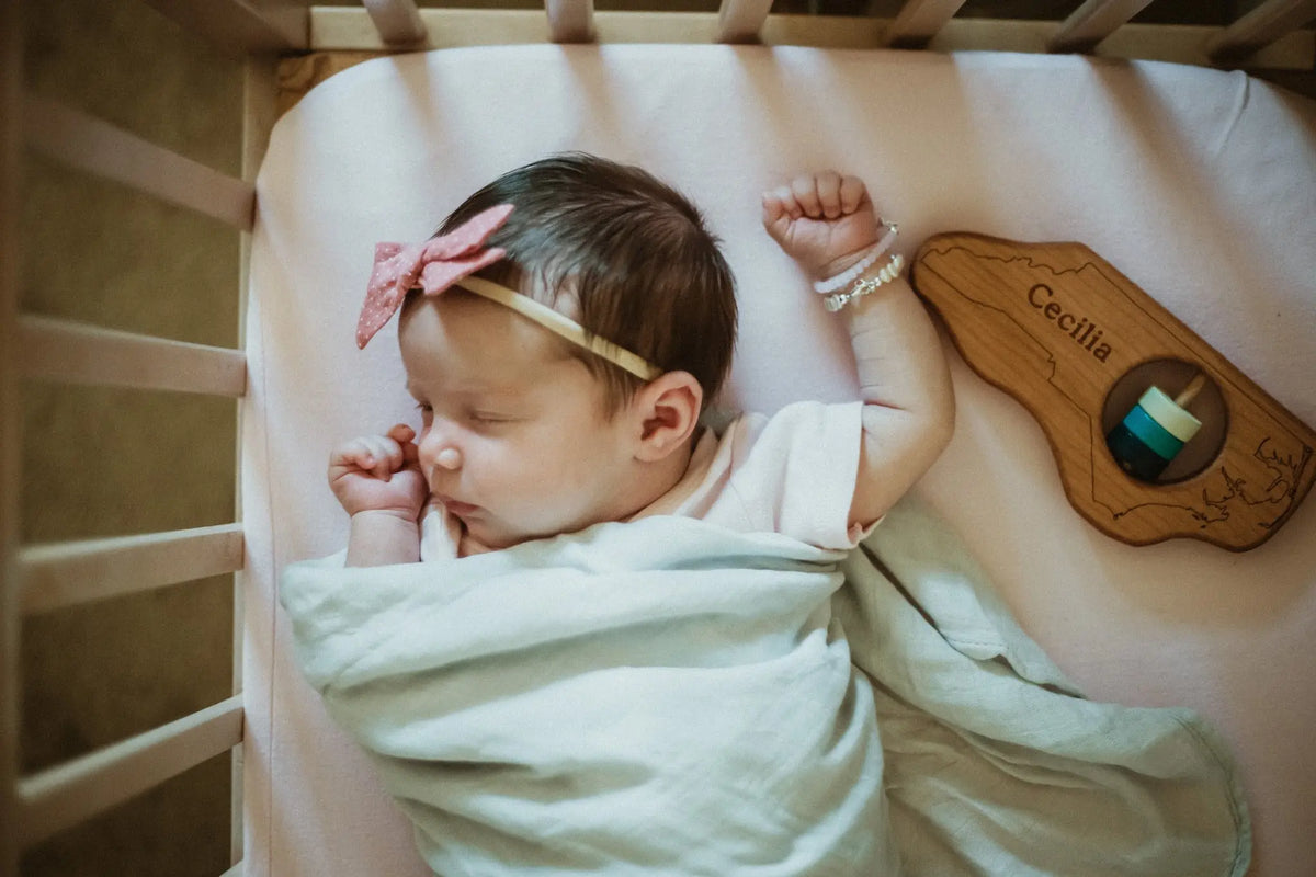 Lifestyle photo showing a wooden state rattle with a child