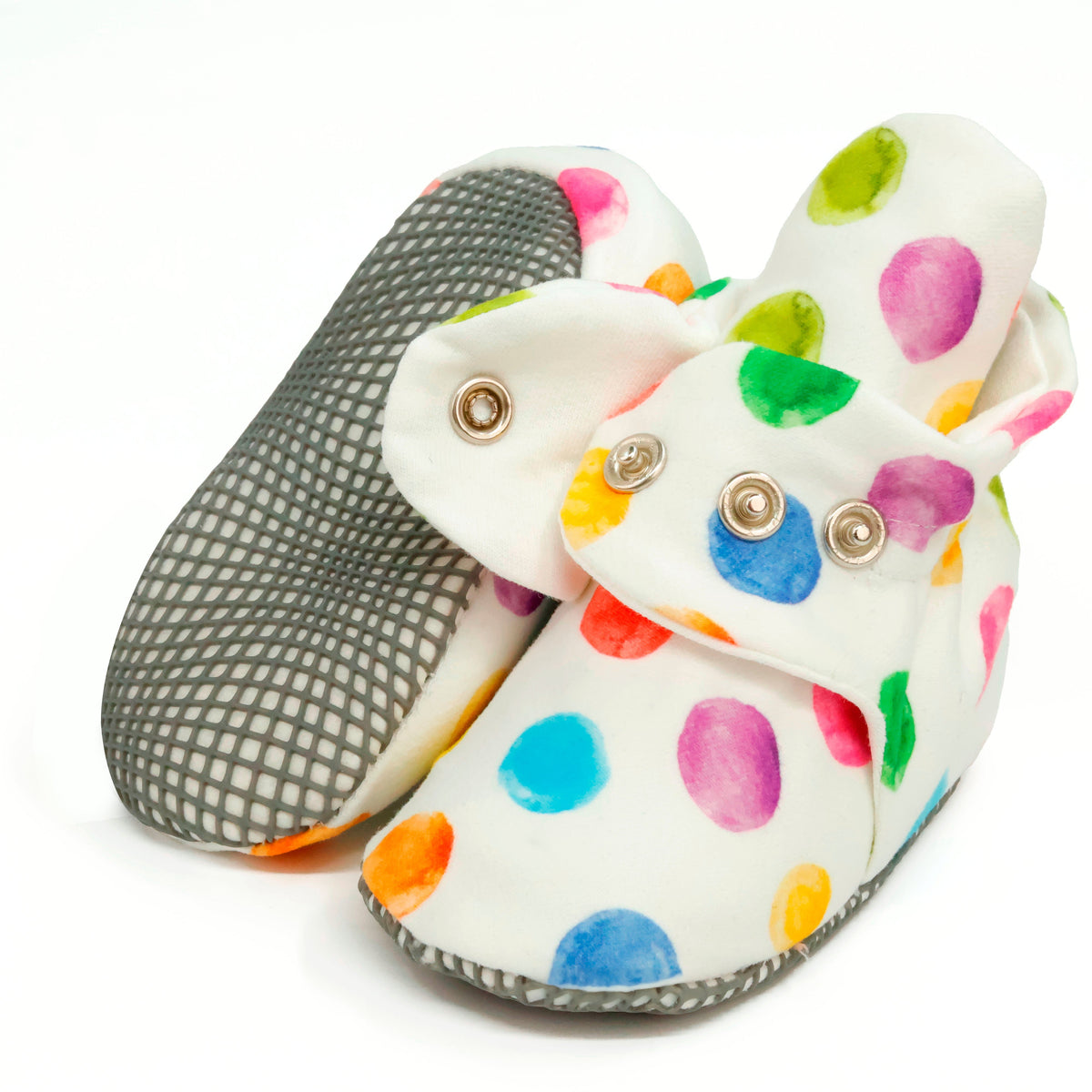 White baby booties with multicolored watercolor dots and snap straps, showing one sole and an open snap strap on white.